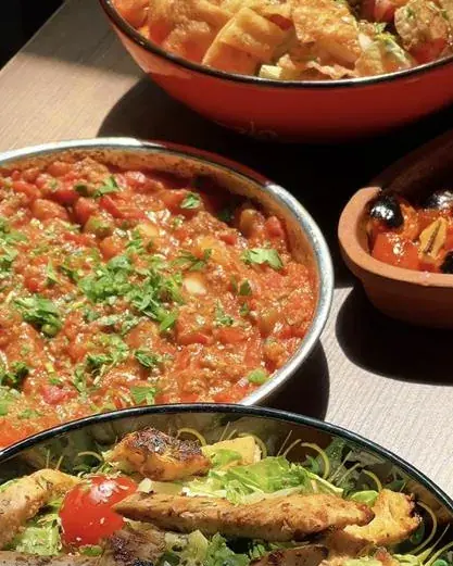 A pan of tomato stew topped with fresh herbs