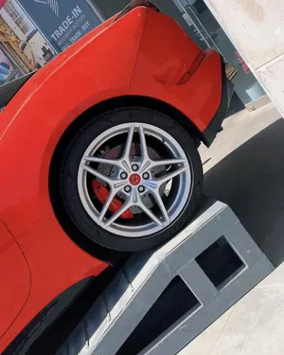 Close-up of the wheel and red brake caliper of a red sports car
