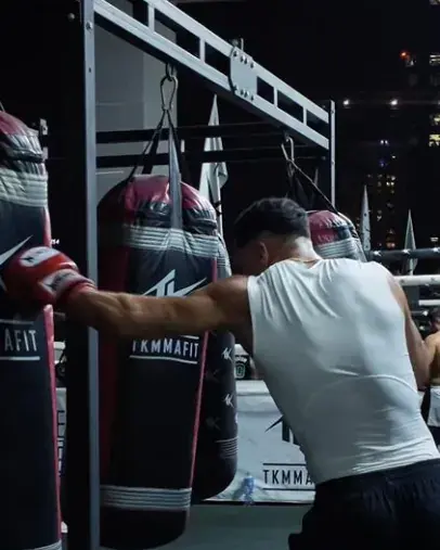 A boxer working a heavy bag in a gym